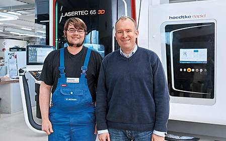 Managing Director Joachim H. Hoedtke (right) in front of his LASERTEC 65 3D at the Hoedtke plant in Pinneberg